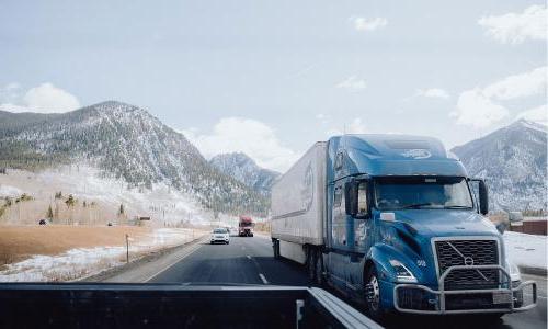 Semi truck driving away from mountains in Colorado